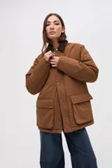 Campera de gabardina color marrón con cuello de pana en tono oscuro. Presenta cierre frontal con botones a presión, bolsillos laterales con solapa y diseño de calce clásico.