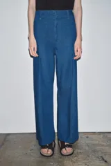 Jeans de tiro alto y pierna ancha de Zara, confeccionados en mezcla de algodón color beige. Presentan cintura con trabillas, bolsillos de parche en la espalda, costuras frontales marcadas y cierre delantero con cremallera, botón y gancho metálico.