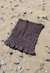 Top bandeau de broderie de algodón en color marrón, con diseño fruncido elástico en todo el cuerpo y terminación con volados pequeños.