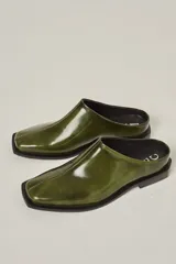 Zuecos color verde oliva de cuero vacuno, con punta cuadrada y suela plana.