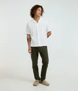 Pantalón masculino de corte skinny confeccionado en sarga de algodón con elastano. Presenta cierre frontal con botón y cremallera, cintura con trabillas y bolsillos laterales y traseros.