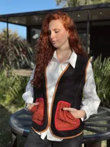 Chaleco negro con interior de corderito, con detalles en color naranja y ribeteado en marrón.