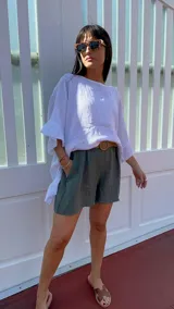 Short de lino color rojo, con cintura elástica y cinturón de rafia con hebilla circular.