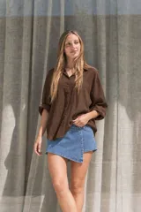 Camisa oversize amarilla de textura liviana, con cuello clásico, mangas largas y cierre frontal con botones.