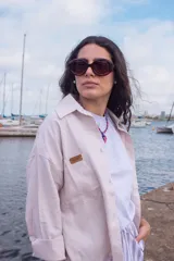 Camisa de lino color beige, de corte oversize, con mangas largas, cuello camisero y bolsillo frontal con etiqueta de cuero con la marca grabada.