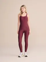Jumpsuit largo de diseño ajustado con escote redondo y tirantes anchos. Confeccionado en tejido con acabado satinado y textura acanalada, cuenta con copas removibles y tecnología de compresión media que se adapta al cuerpo.