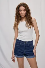 Short de jean de tiro medio, con diseño clásico de cinco bolsillos, cierre frontal con botón y terminación con vuelta en el ruedo.