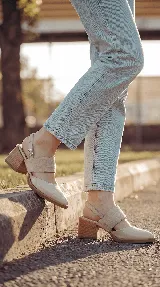 Zapato de taco ancho y medio, color negro, confeccionado en cuero. Presenta diseño destalonado con tira ajustable en el talón, faja ancha de gamuza sobre el empeine y puntera fina de charol.