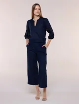 Pantalón crop de lino y algodón color azul marino, con calce holgado, cintura elástica, bolsillos laterales y detalle de puntilla en los laterales de las piernas.