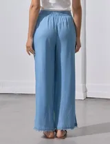 Pantalón celeste de lyocell, corte ancho, con pretina elastizada con lazo de ajuste, bolsillos verticales y ruedo desflecado.