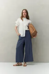 Pantalón amplio de corte recto y tiro medio, confeccionado en mezcla de lino y viscosa color azul marino, con bolsillos laterales y elástico en la cintura trasera.