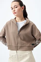 Canguro cropped negro con cierre frontal y estampa abstracta en contraste en las mangas.