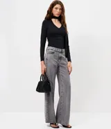 Blusa entallada de microfibra color blanco, con escote en V, mangas largas y detalle de frunces en los laterales. Presenta un lazo integrado en el cuello que permite anudarlo, aportando un toque sofisticado al diseño.