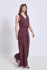 Pantalón ancho de tiro alto color vino, con pliegues frontales y bolsillos laterales.