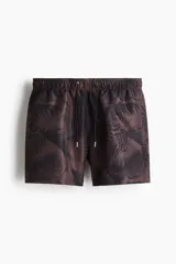 Short de baño con estampado de hojas en tonos oscuros, cuenta con cintura elástica con cordón ajustable, bolsillos laterales y un bolsillo trasero. Incluye suspensor interior de malla.