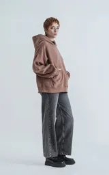 Hoodie oversize de corte crop en color marrón, confeccionado en frisa gamuzada de algodón. Presenta capucha forrada, bolsillo tipo canguro frontal y puños y ruedo acanalados.