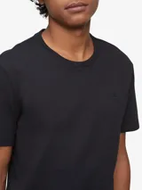 Remera de algodón lisa color negro, de manga corta, con cuello redondo y discreto monograma bordado de la marca Calvin Klein en el pecho.
