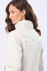 Campera de neopreno en color blanco hueso, con cierre frontal y botones a presión. Presenta cuello alto, mangas largas y bolsillos laterales. Diseño funcional y versátil para uso diario.