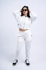 Conjunto deportivo compuesto por una campera corta con cierre frontal y un pantalón tipo jogging, ambos en color blanco.