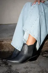 Botas tipo chelsea de cuero negro, con elásticos laterales y taco bajo cuadrado.