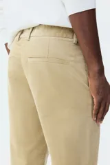 Pantalón de pana de corte regular fit, color beige, con cierre de botón y cremallera, bolsillos laterales y trabillas para cinturón.