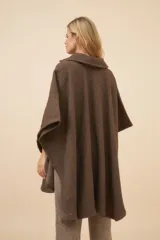 Poncho marrón de lana fina sin teñir, con cuello y cuadrado aplicado con broche a presión.