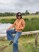 Chaqueta corta de cuero ovino color camel, con cuello redondo, cierre frontal con botones a presión y bolsillos laterales. Diseño holgado y flexible.