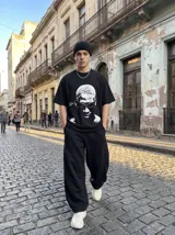 Pantalon deportivo de corte baggy y silueta oversize, confeccionado en algodon. Presenta cintura elastizada y costuras decorativas verticales que estructuran el diseño de las piernas.