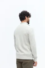 Buzo de algodón color azul marino con medio cierre frontal y cuello alto. Presenta un pequeño logo bordado en el pecho.