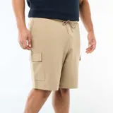 Bermuda de punto piqué color beige, de corte relajado, con bolsillos cargo con solapa en los laterales y cordón ajustable en la cintura.