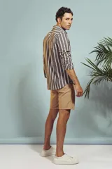 Camisa de manga larga en color salmón con estampado de pequeños motivos geométricos oscuros, cuello clásico y cierre frontal con botones.