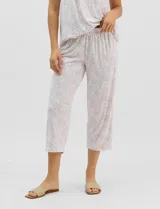 Pijama compuesto por remera sin mangas con escote redondo, botones frontales y detalle de puntilla, acompañado de un pantalón capri con cintura elástica. Presenta un estampado floral en tonos rosados sobre base gris.