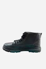 Bota corta de cuero sintético color marrón, con cordones, suela chunky y cierre lateral.