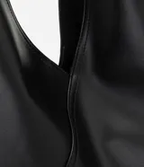 Cartera hobo de Satinato de tamaño mediano color negro, confeccionada en poliuretano con recortes estructurados y diseño flexible con asa de hombro fija.