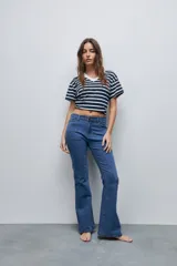 Jean flare de tiro medio, color celeste, con calce al cuerpo hasta la rodilla y pierna levemente acampanada.