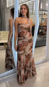 Vestido largo strapless con diseño estampado estilo abstracto en tonos marrones y beige, con detalle de bufanda o lazo al cuello del mismo género y corte sirena con caída fluida.