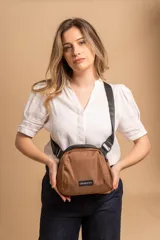 Bandolera de diseño compacto confeccionada en tafeta liviana color marrón. Cuenta con cierre superior, correa ajustable ancha de color negro y etiqueta frontal con el logo de la marca.