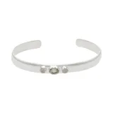 Brazalete rígido abierto de plata 925 con tres piedras engarzadas: una piedra de peridoto ovalada en el centro y dos piedras de la luna redondas a los lados.