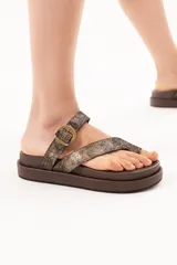 Sandalia de cuero con base acolchonada y plataforma, diseño de tiras cruzadas con agarre en el dedo y hebilla metálica. Cuentan con acabado metalizado.