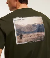 Remera de corte comfort color verde militar, de manga corta, con cuello redondo y estampado frontal pequeño con la leyenda "Speed on the rocks".