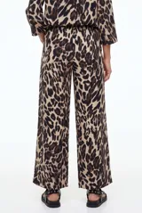 Pantalon tipo palazzo color negro con estampado paisley en tonos beige y blanco, corte holgado y tiro medio.