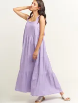 Vestido largo lila con volados en diferentes tamaños, escote cuadrado y lazos en la espalda.