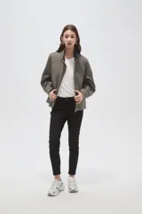 Campera de corte holgado en color gris, con cuello alto, cierre frontal oculto y mangas largas. Presenta costuras decorativas en el frente y bolsillos laterales.