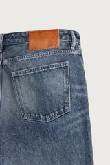 Jeans flare fit de denim negro, tiro medio, ajustados arriba y con botamanga acampanada. Cuentan con cinco bolsillos, lavado efecto gastado y bajo con acabado irregular. Cierre frontal con cremallera y botón.