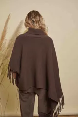 Poncho tejido de punto acanalado en color marrón chocolate, con cuello alto y diseño irregular con flecos en los bordes.