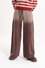 Jean wide leg de tiro medio con efecto desteñido en tono marrón y detalles desflecados en los bolsillos delanteros. Incluye un lazo de tela ajustable en la cintura.