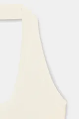 Top color crema de tejido de punto con cuello halter y escote redondo.