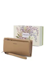 Billetera de mujer tipo sobre con correa de mano extraíble, confeccionada en material texturizado color tostado. Presenta un bolsillo frontal con cierre, compartimentos internos para tarjetas y logo de la marca grabado en el frente.