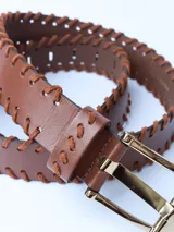 Cinturón marrón de cuero con costuras gruesas en contraste y hebilla metálica dorada.