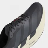 Championes de running Adidas Adizero Evo SL, color gris oscuro con entresuela de espuma Lightstrike Pro en tono crema y las características tres tiras de la marca en un tono gris más claro.